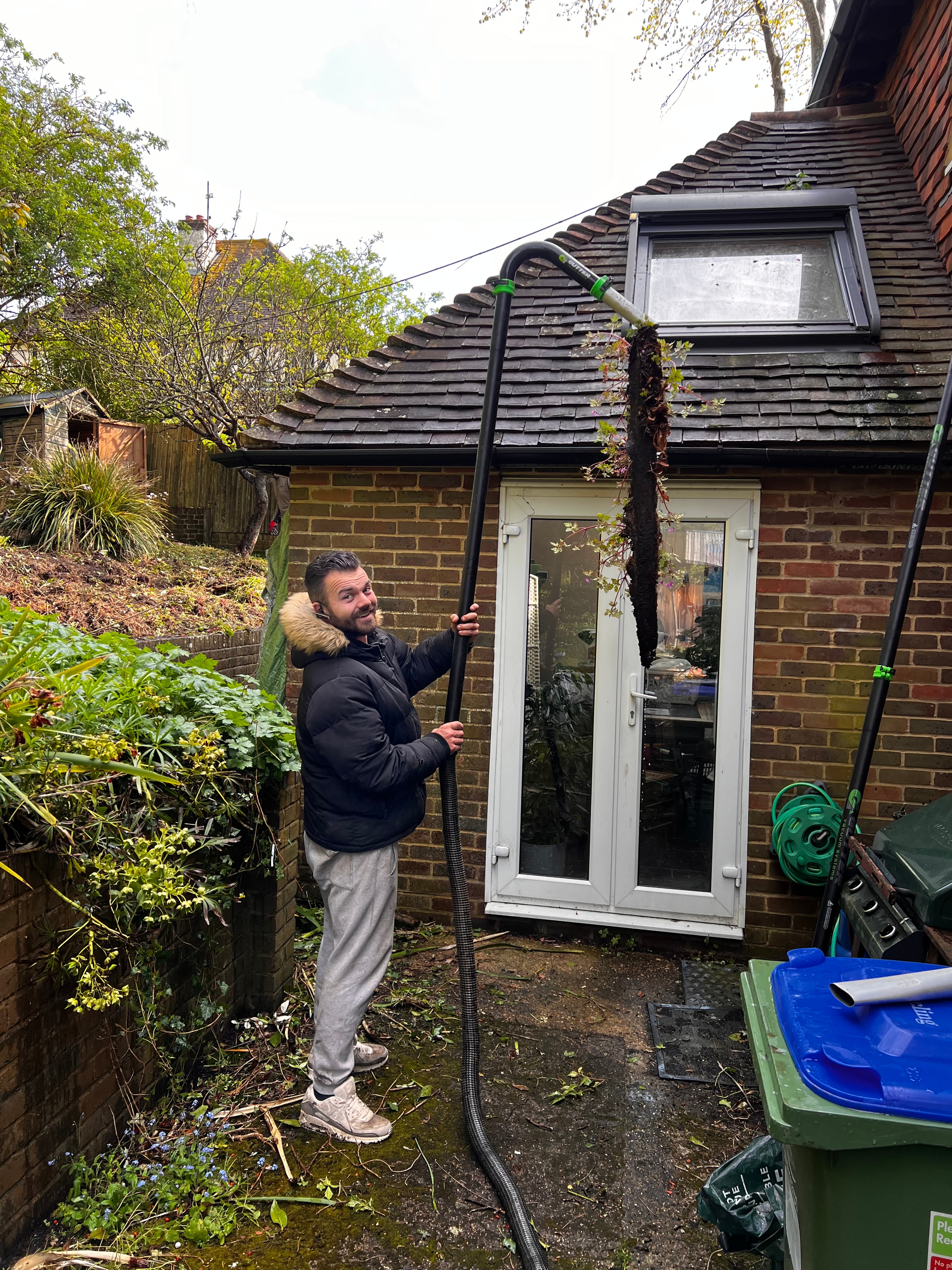 Gutter cleaning operative at work on a Sussex property