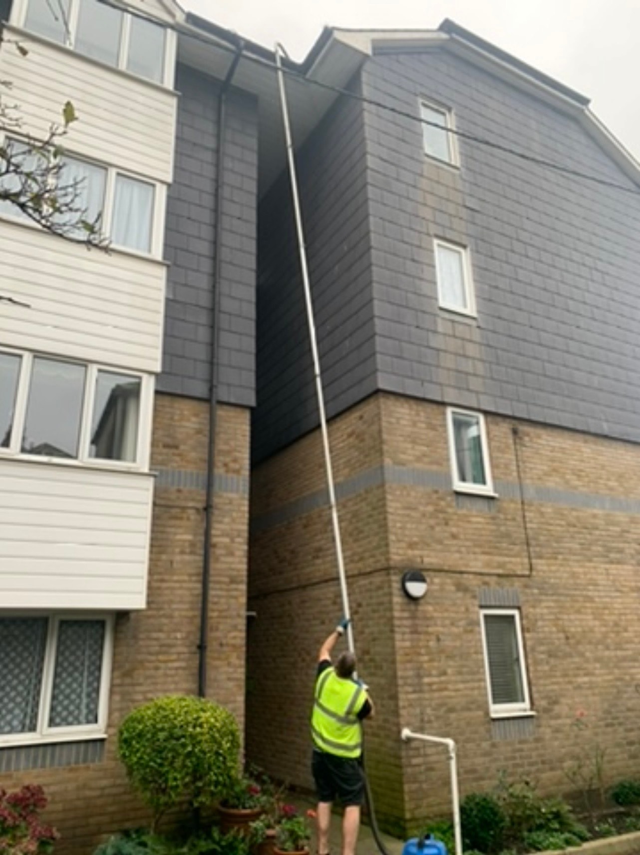 Operative cleaning gutters on a tall block of flats